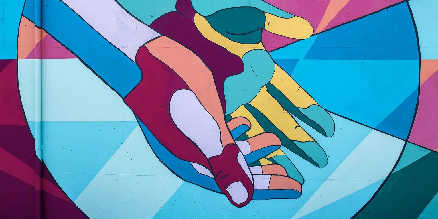 Colourful mural of two abstractly drawn hands, with overlapping geometric shapes in the background.
