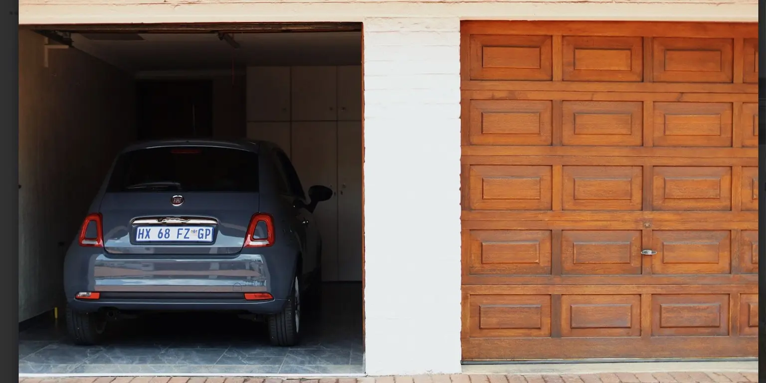 Gray car parked in a garage, suggesting savings on accident cover by not driving in December.